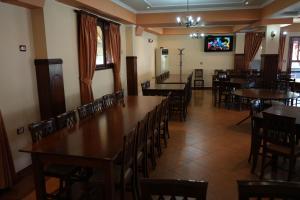 a dining room with tables and chairs and a tv at HOTEL RESTORANT VIKTORIA in Gjirokastër