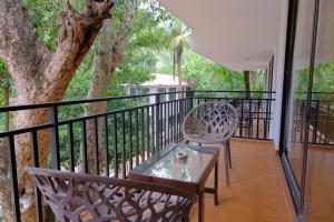 einen Balkon mit 2 Stühlen, einem Tisch und einem Baum in der Unterkunft The Byke Royal Pearl Anjuna in Anjuna
