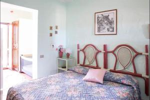 ポザーダにある3 bedrooms apartement with sea view enclosed garden and wifi at Posada 2 km away from the beachのベッドルーム1室(ピンクの枕が付いたベッド1台付)