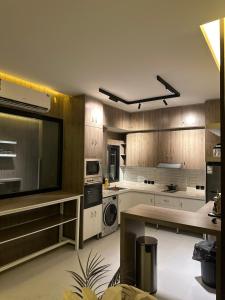 a large kitchen with white appliances and wooden cabinets at شاليه الفيصل in Al Kura