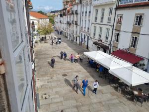 un grupo de personas caminando por una calle de la ciudad en Hostal O Patron, en Santiago de Compostela