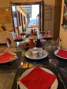 een tafel met borden en rode servetten bij Foresteria Castello di Perno in Monforte dʼAlba