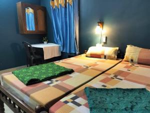 - une chambre avec 2 lits et une table dans l'établissement Sajeev Home Stay, à Cherai Beach