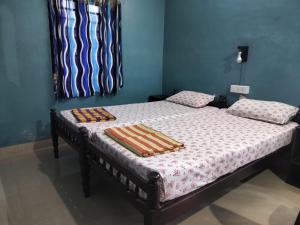 een bed met twee dekens in een slaapkamer bij Sajeev Home Stay in Cherai Beach