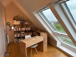 an attic room with a desk and a window at Penty Face à L'Océan in Plozévet