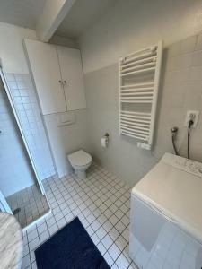 a white bathroom with a toilet and a sink at Penty Face à L'Océan in Plozévet +26 photos