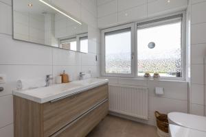 ein weißes Badezimmer mit Waschbecken und Fenster in der Unterkunft Welcome in - Vakantiehuis - Lepelblad 97 - Nieuwvliet-Bad in Nieuwvliet + 36 Fotos