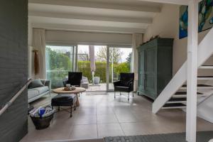 uma sala de estar com uma escada e uma mesa e cadeiras em Vakantiehuis - Lepelblad 97 - Nieuwvliet-Bad em Nieuwvliet