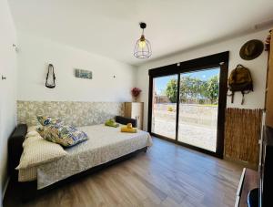 a bedroom with a bed and a large sliding glass door at Rancho Tropicana in Elche