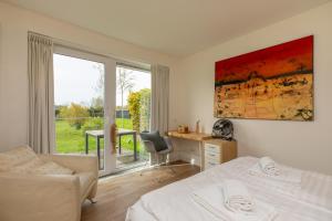 um quarto com uma cama, uma secretária e uma janela em Vakantiehuis - Lepelblad 97 - Nieuwvliet-Bad em Nieuwvliet