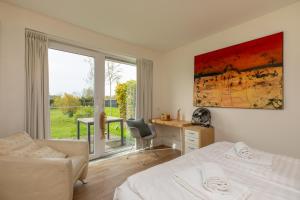 ein Schlafzimmer mit Bett, Schreibtisch und Fenster in der Unterkunft Welcome in - Vakantiehuis - Lepelblad 97 - Nieuwvliet-Bad in Nieuwvliet