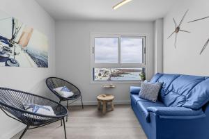 een woonkamer met een blauwe bank en 2 stoelen bij Casa Azul by Escape Home in Punta de Mujeres