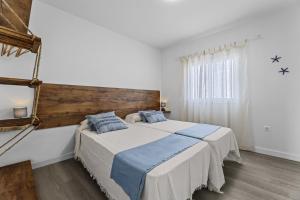 een slaapkamer met een groot bed en een raam bij Casa Azul by Escape Home in Punta de Mujeres