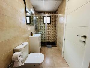 a small bathroom with a toilet and a shower at Rancho Tropicana in Elche
