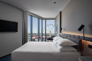 メルボルンにあるVibe Hotel Melbourne Docklandsの大型ベッドと大型車輪付きのホテルルームです。