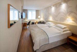 a hotel room with a large bed and a desk at Boutique Hotel Das Tigra in Vienna