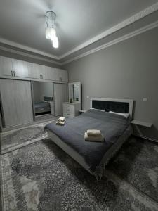 a bedroom with a bed with two towels on it at City Plaza Zarhal in Samarkand