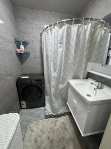 a bathroom with a sink and a shower curtain at City Plaza Zarhal in Samarkand