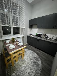 a kitchen with a wooden table and a kitchen with a sink at City Plaza Zarhal in Samarkand