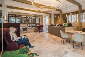 a woman sitting in a chair in a hotel lobby at Heritage Hotel Hallstatt in Hallstatt