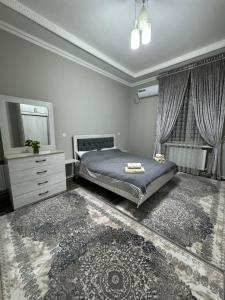 a bedroom with a bed and a dresser and windows at City Plaza Zarhal in Samarkand
