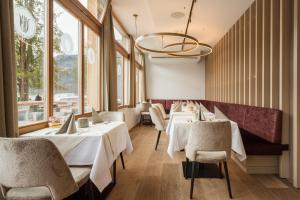 a restaurant with white tables and chairs and windows at Heritage Hotel Hallstatt in Hallstatt