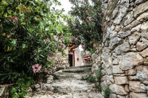 un callejón con flores y escaleras en una pared de piedra en Villa rurale nei pressi Castello, en Campello sul Clitunno