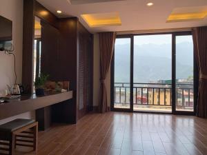 a living room with a large window with a view at Sapa Meriton Boutique Hotel in Sapa
