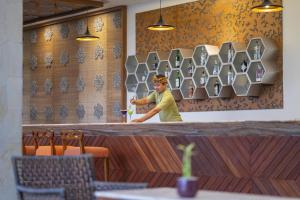 a man standing behind a counter in a restaurant at MERUSAKA Nusa Dua in Nusa Dua +37 photos