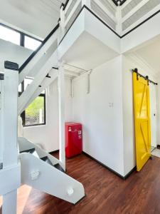 Habitación con escalera y nevera roja. en Tiny House & Pool 4 pax 3 mins Merang Jetty, en Setiu