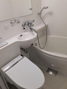 ein Bad mit einem WC und einem Waschbecken in der Unterkunft ホテルジャパネスク京都駅 COTONE in Nishi-kujō-Toriiguchichō