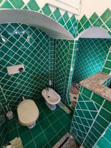 La salle de bains est pourvue de carrelage vert, de toilettes et d'un lavabo. dans l'établissement Vista Panoramica a 5 minuti dal Lago Liscia, à Sant Antonio Di Gallura