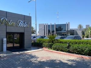 a building with a sign in a parking lot at Palm Hotel in Baghdad
