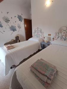 - une chambre d'hôtel avec 2 lits et une serviette dans l'établissement Vista Panoramica a 5 minuti dal Lago Liscia, à Sant Antonio Di Gallura