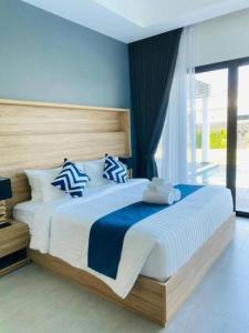 a bedroom with a large bed with blue walls at Sivana Villas Hua Hin in Hua Hin