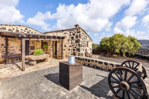 an old stone building with a cannon in front of it at Casa Rural Vega de Timanfaya in Uga