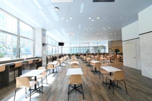 a cafeteria with tables and chairs and windows at Toyoko Inn Changwon in Changwon