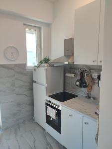 una cucina con elettrodomestici bianchi e un orologio sul muro di Mateja38 a Belgrado