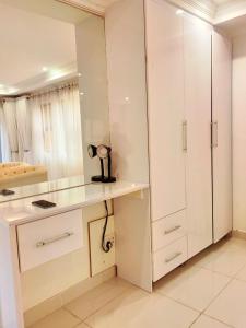 a white kitchen with a desk and cabinets at GEORGE B BOUTIQUE LODGE in Tzaneen