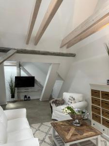 a living room with white furniture and a table at Sievershof Sieversloft in Wietzendorf