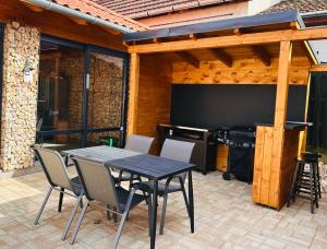 een patio met een tafel en stoelen en een groot televisiescherm bij Bikeaway Guesthouse in Kereki