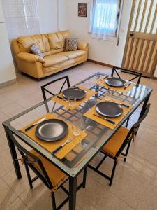 a dining room table with chairs and a glass table top at Trapani Emotions apartment in Valderice