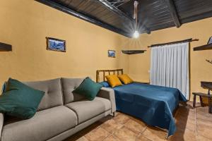 uma sala de estar com um sofá e uma cama em Casa Rural Vega de Timanfaya em Uga