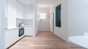 a kitchen with white cabinets and a wooden floor at Italianway - Washington 2 in Milan