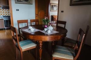 une table à manger avec des chaises et une table en bois avec des tasses à thé dans l'établissement Casa Dalla Nita, à San Vito Rimini