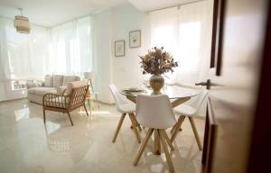 uma sala de estar branca com uma mesa e cadeiras em Prada Suite Home em Córdoba