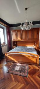 ein Schlafzimmer mit einem großen Holzbett mit einem Kronleuchter in der Unterkunft Fewo Haus Cäcilia in Elsdorf