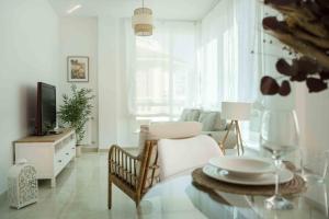 uma sala de estar branca com uma mesa e uma televisão em Prada Suite Home em Córdoba