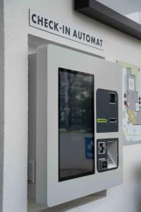 einem Geldautomaten mit dem Schild-Check-in-Begleiter in der Unterkunft K-Apart Hotel & Boardinghouse in Hürth