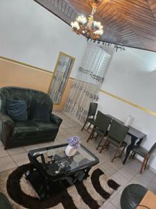ein Wohnzimmer mit einem Ledersofa und einem Tisch in der Unterkunft Logé express in Douala